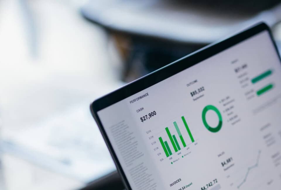 A laptop screen displaying a financial dashboard with charts and graphs.